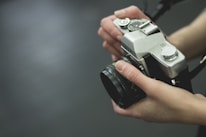 Close-up of hands holding a vintage camera, highlighting the art of storytelling.