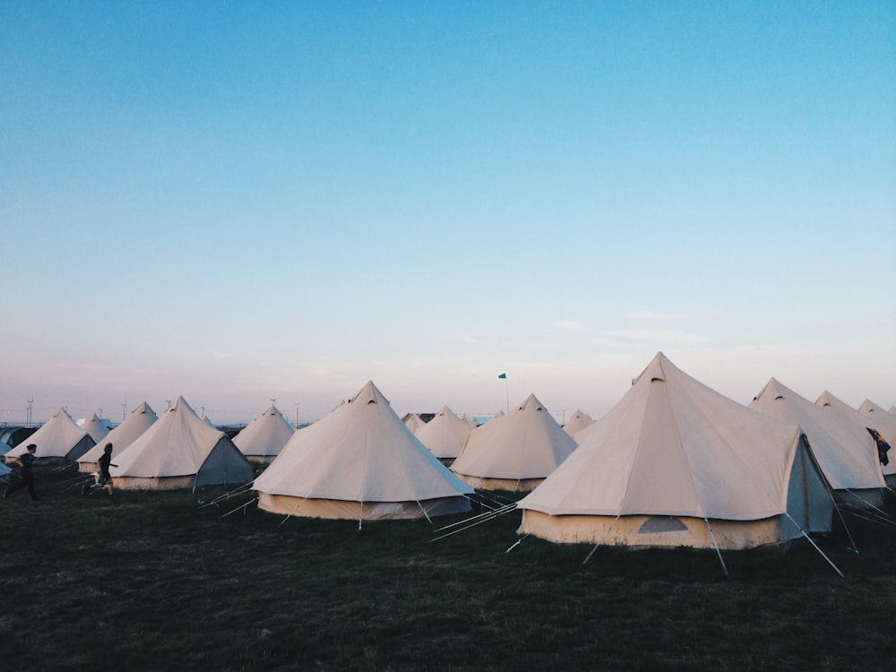 white tents on grass field under clear blue sky