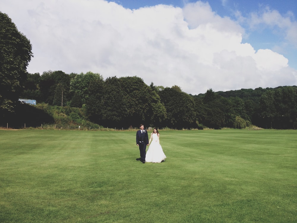 couple standing on grass field