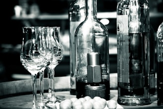 Elegant wine bottles and glasses arranged on a rustic wooden table.