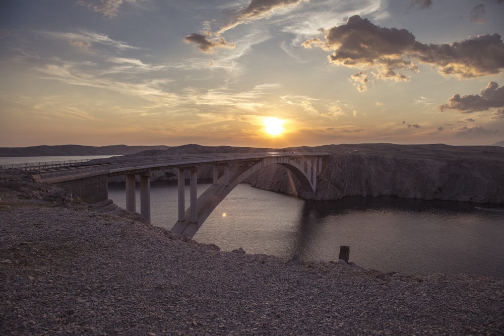 brown wooden bridge over river during sunset