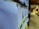 Several sheets of paper with printed tables are clipped to a bulletin board in a corridor. The papers appear to contain data or results, indicated by numerical values and columns.