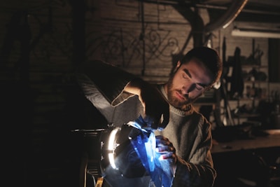 Technician adjusting stage lighting with colorful LEDs glowing in the background