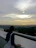 Circular photo of a thoughtful man looking out over a city skyline at sunset.