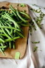 green peas on top of brown wooden chopping board