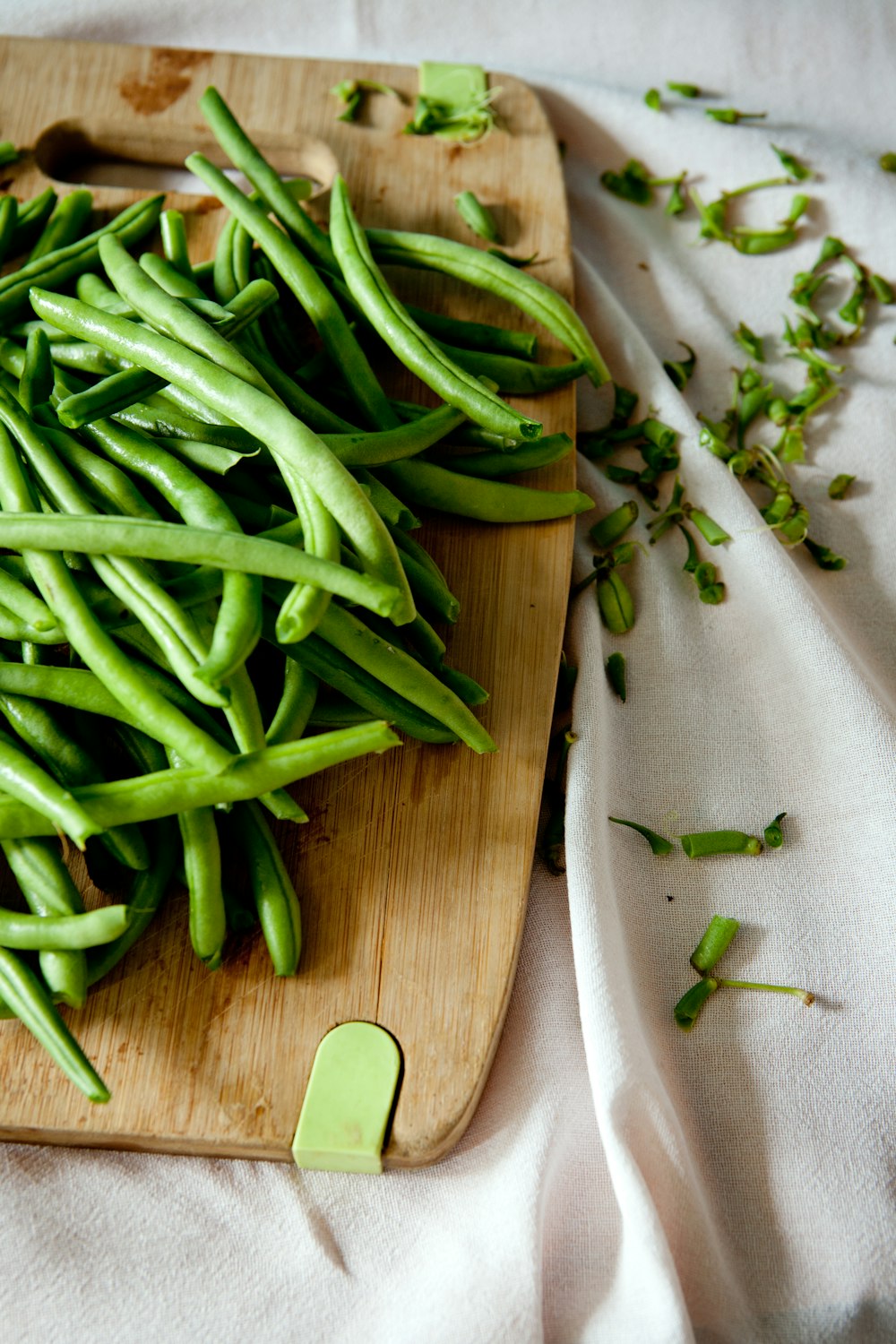 guisantes verdes encima de una tabla de cortar de madera marrón