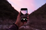 person holding iPhone displaying camera application