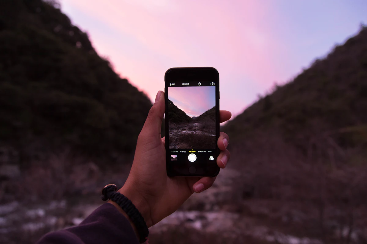 Main tenant un iPhone dont l'application appareil photo est ouverte