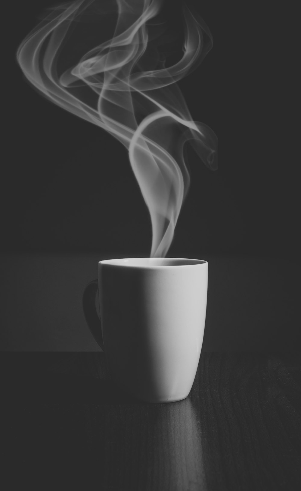 A hot drink in a white cup, with steam rising into the air.