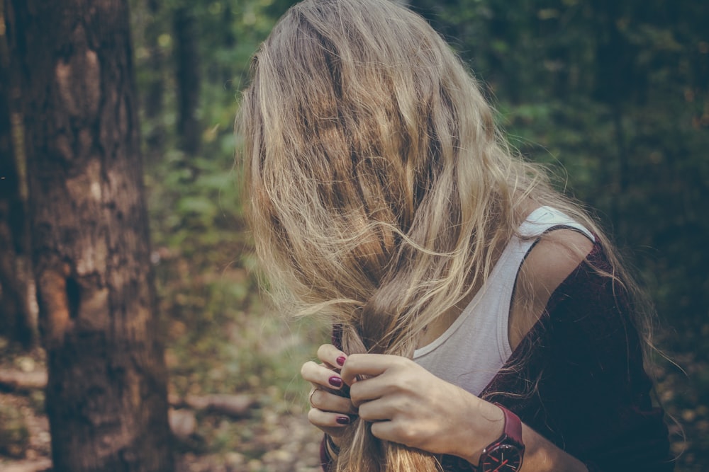 woman holding her hair in forest