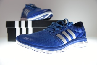 Customer shopping online for sport shoes using a laptop with boxes of shoes nearby.