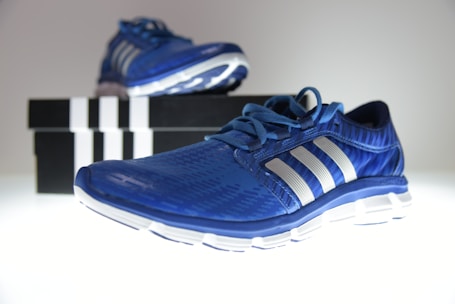 Customer shopping online for sport shoes using a laptop with boxes of shoes nearby.