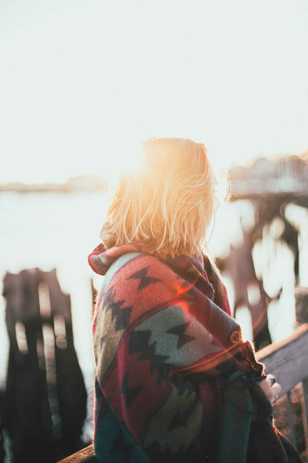 woman covered by multicolored aztec blanket