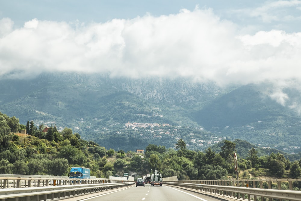 people walking on road near green mountains during daytime