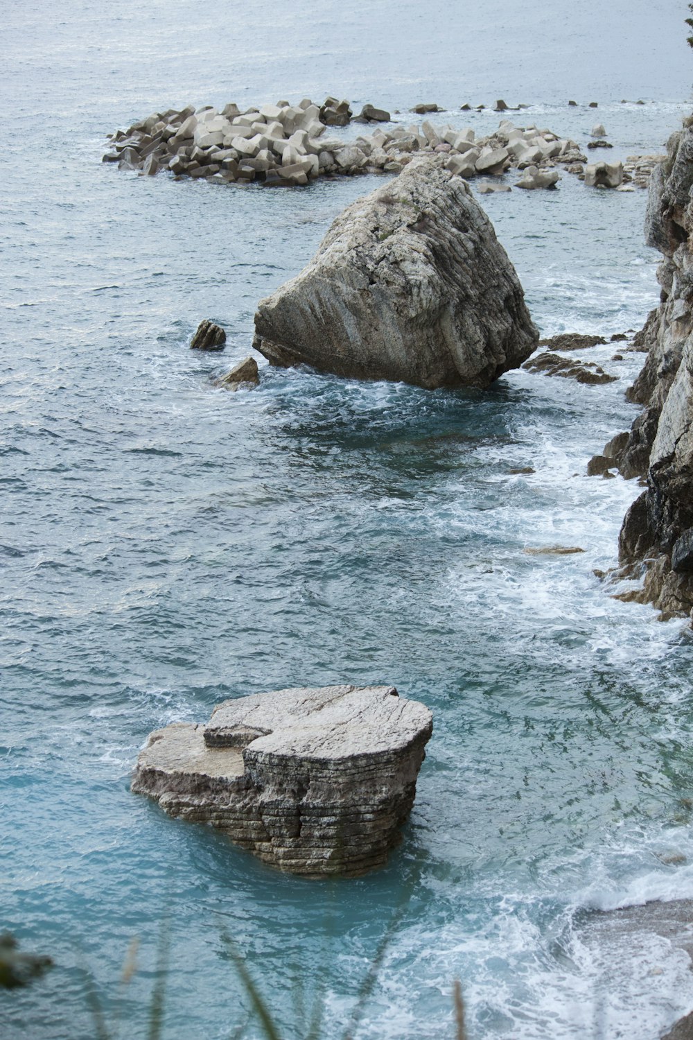 brown rock formation on body of water during daytime