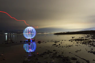 A mysterious glowing orb floating above a dark lake at twilight.
