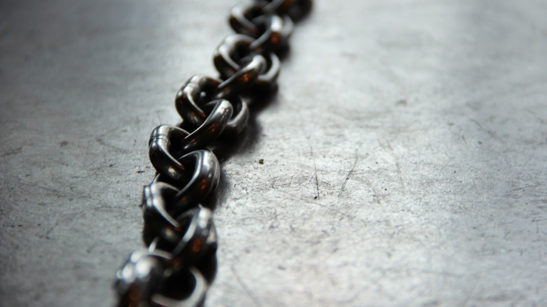 Close-up of a broken metal chain link, rusted at the fracture