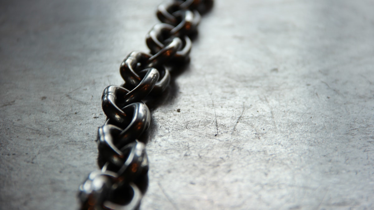 Monochrome photograph of a heavy chain laid on the floor