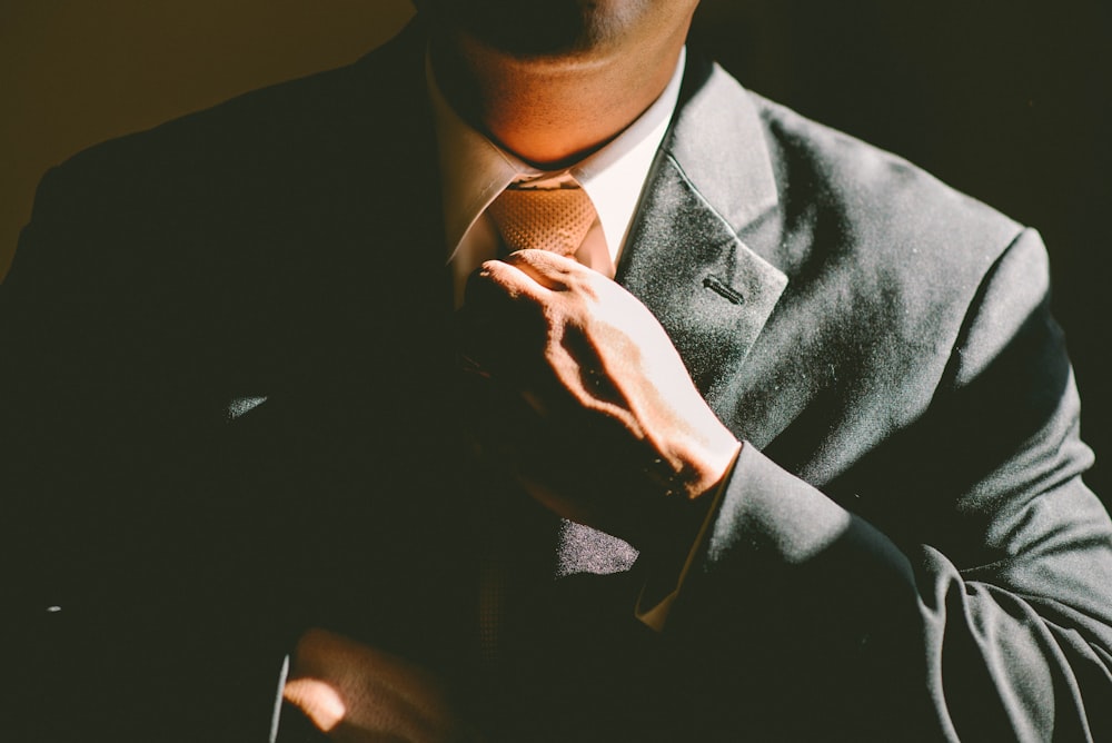 Ein Mann im schwarzen Anzug, der seine Krawatte lockert