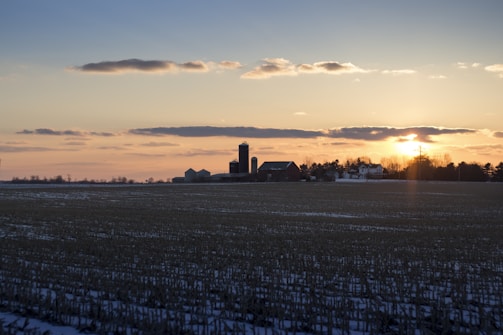 Sunset over a large farm with irrigation systems visible.