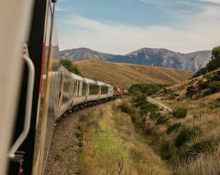 white train with the distance of mountain during daytime by Josh Nezon (@jnezon)