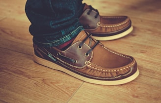 person wearing pair of brown leather shoes