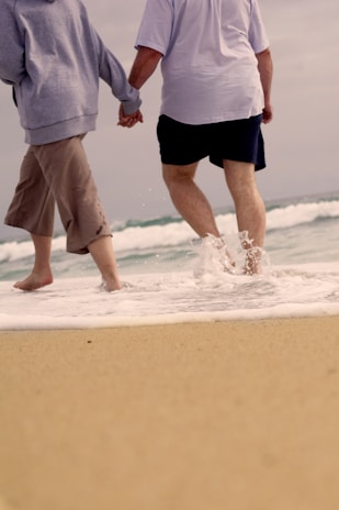 Couple walking hand in hand along the beach just steps from Maréflat.