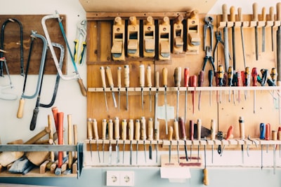 assorted handheld tools in tool rack workshop zoom background