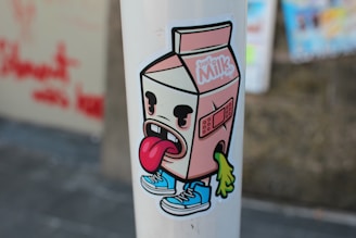 a sticker of a milk carton with a tongue sticking out of it