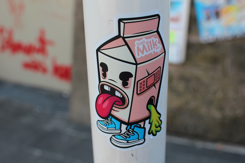 a sticker of a milk carton with a tongue sticking out of it