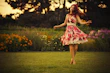 A joyful child twirling in a bright, playful dress in a sunlit garden.