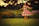 Smiling little girl twirling in a soft pink floral dress outdoors