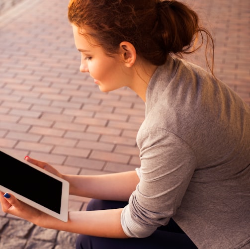 woman holding white iPad