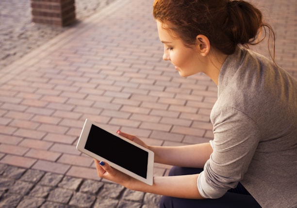 woman holding white iPad