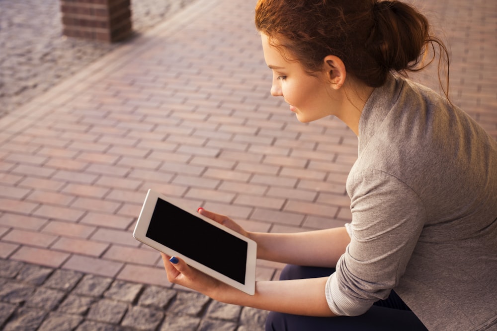 woman holding white iPad