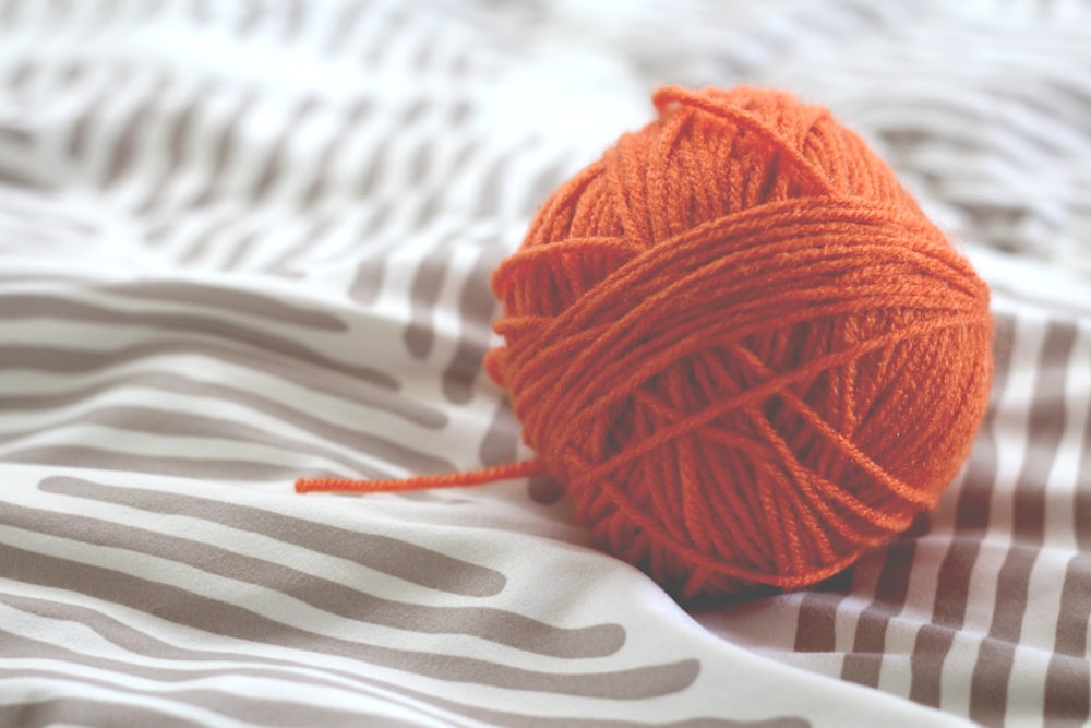 orange yarn ball on white and gray pad