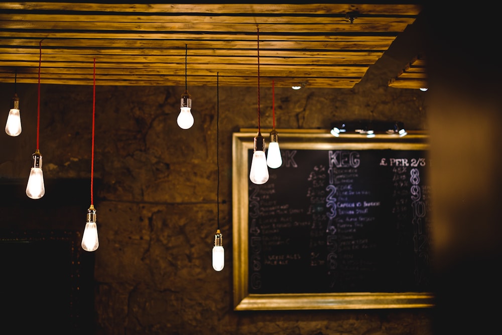 turned on pendant bulb lot beside wall decor