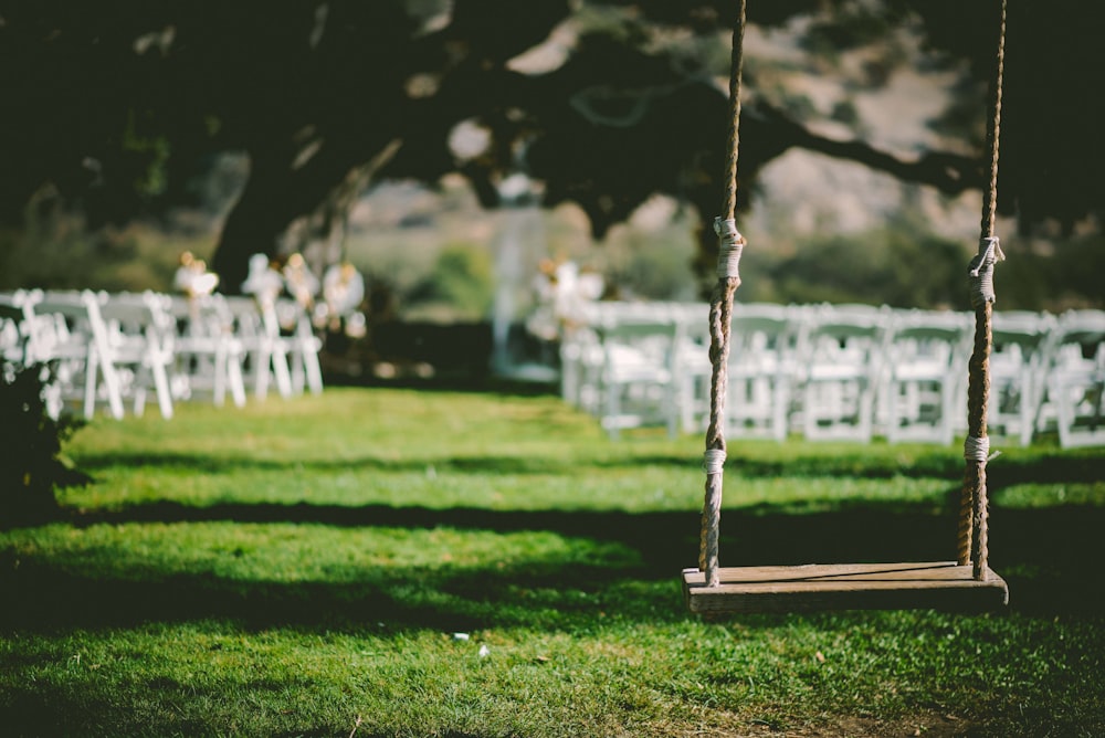 closeup photo of brown wooden swing during daytime