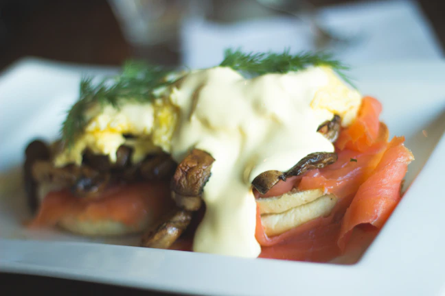 An inviting plate of scrambled eggs with spinach and smoked salmon, garnished with chives.
