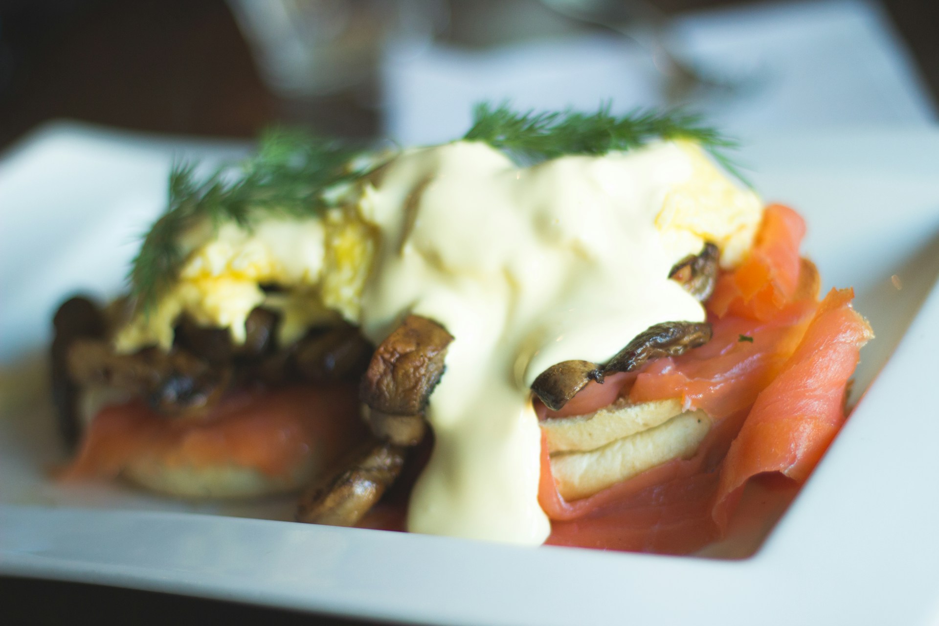 A beautifully plated dish of varied eggs benedict with salmon and avocado, showcasing the restaurant's brunch specialties.