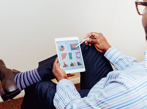 person sitting on chair holding iPad