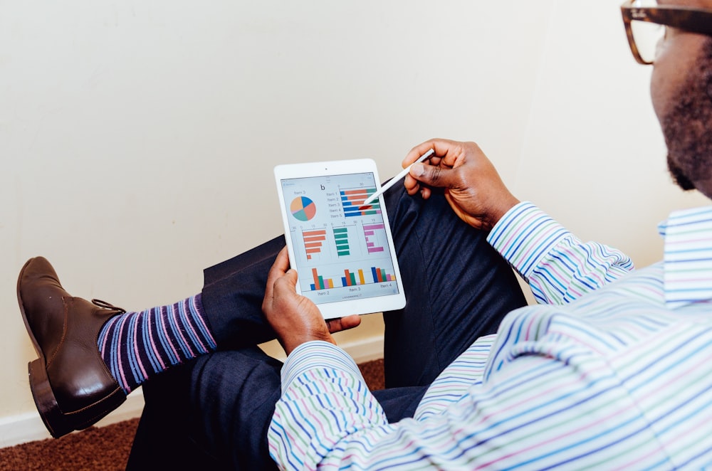 A business man taking marketing analytics technologically on an ipad tablet in his office