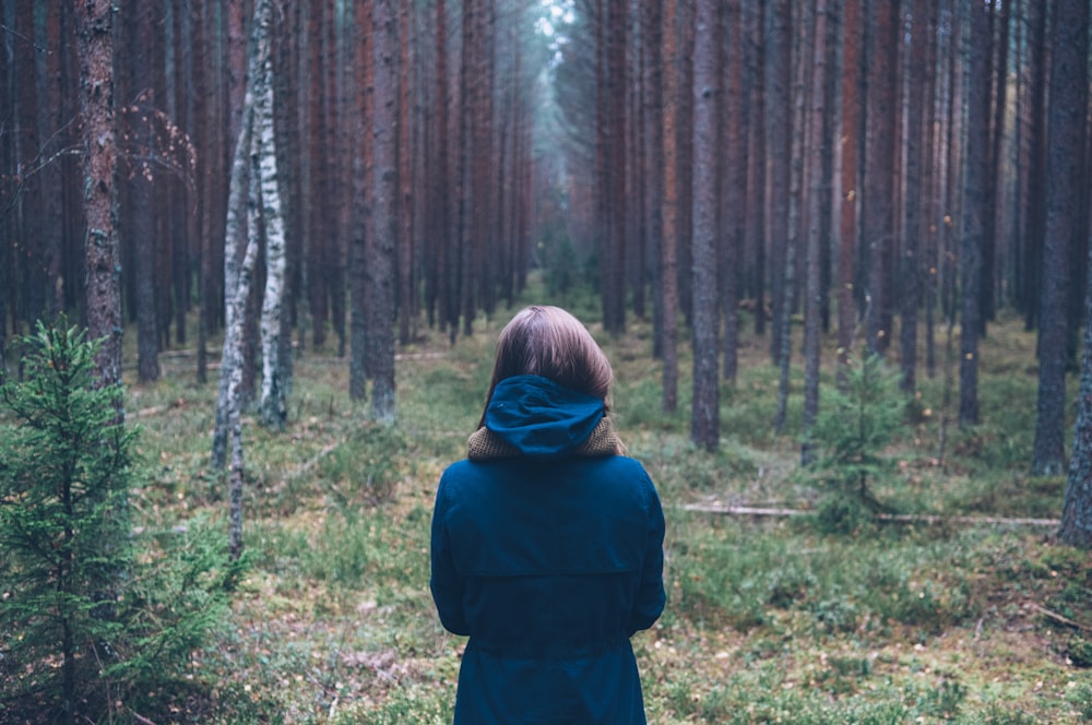 Mujer con sudadera con capucha en el bosque