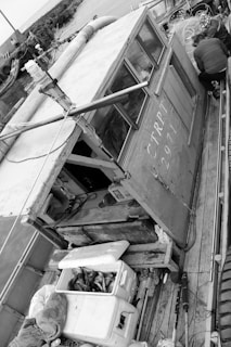 A commercial fisherman using a tablet inside a boat wheelhouse, logging catch data with FishTrak Catch Plotter.