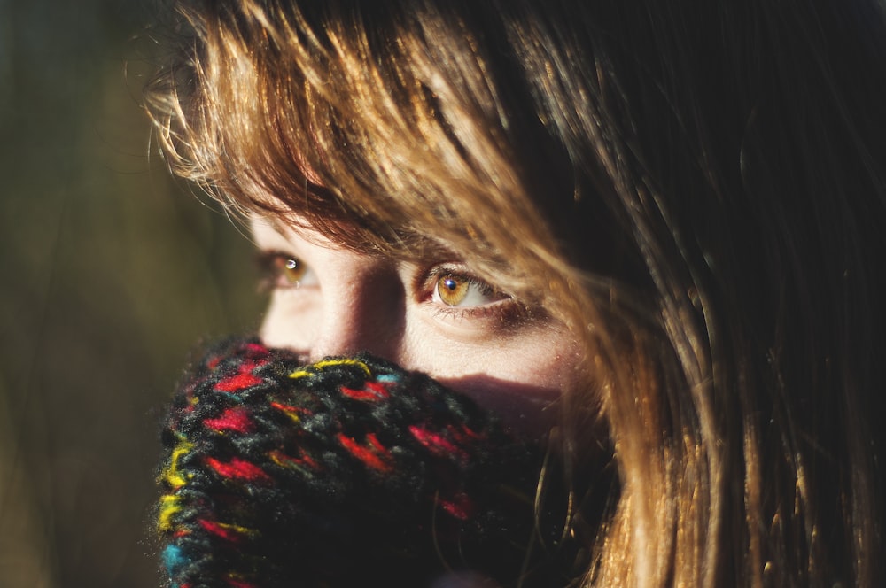 woman covering her multicolored knit mask