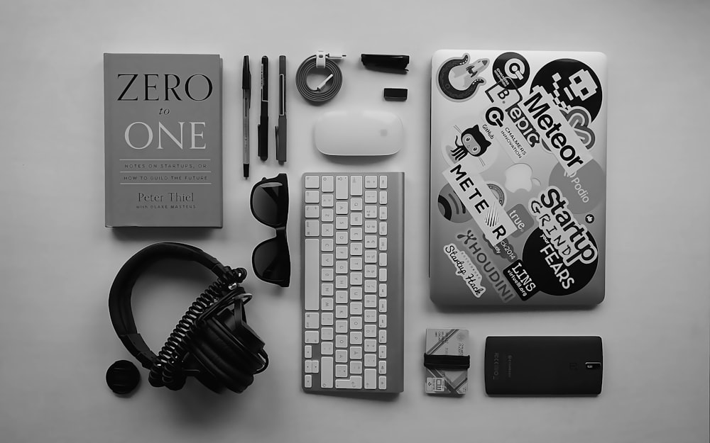 black corded headphones, silver MacBook, Apple wireless keyboard, and Apple Magic Mouse