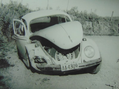 A close-up of a damaged car being carefully inspected by an appraiser holding a clipboard.
