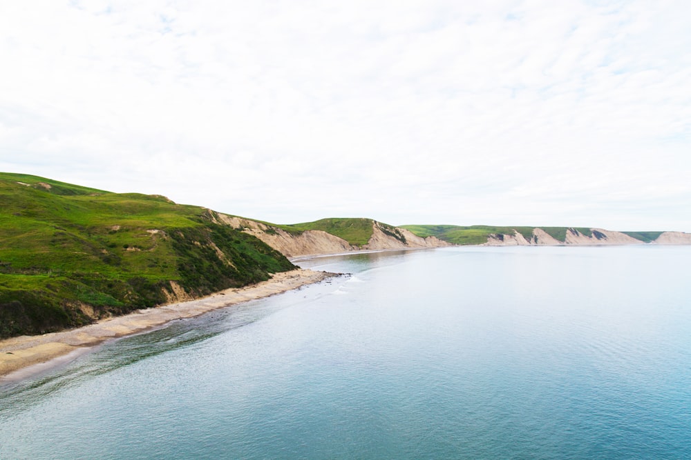 green mountain cliff near ocean