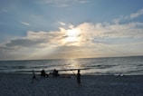A peaceful family moment at sunset, with fathers and children playing on the beach.