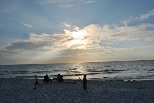A peaceful family moment at sunset, with fathers and children playing on the beach.